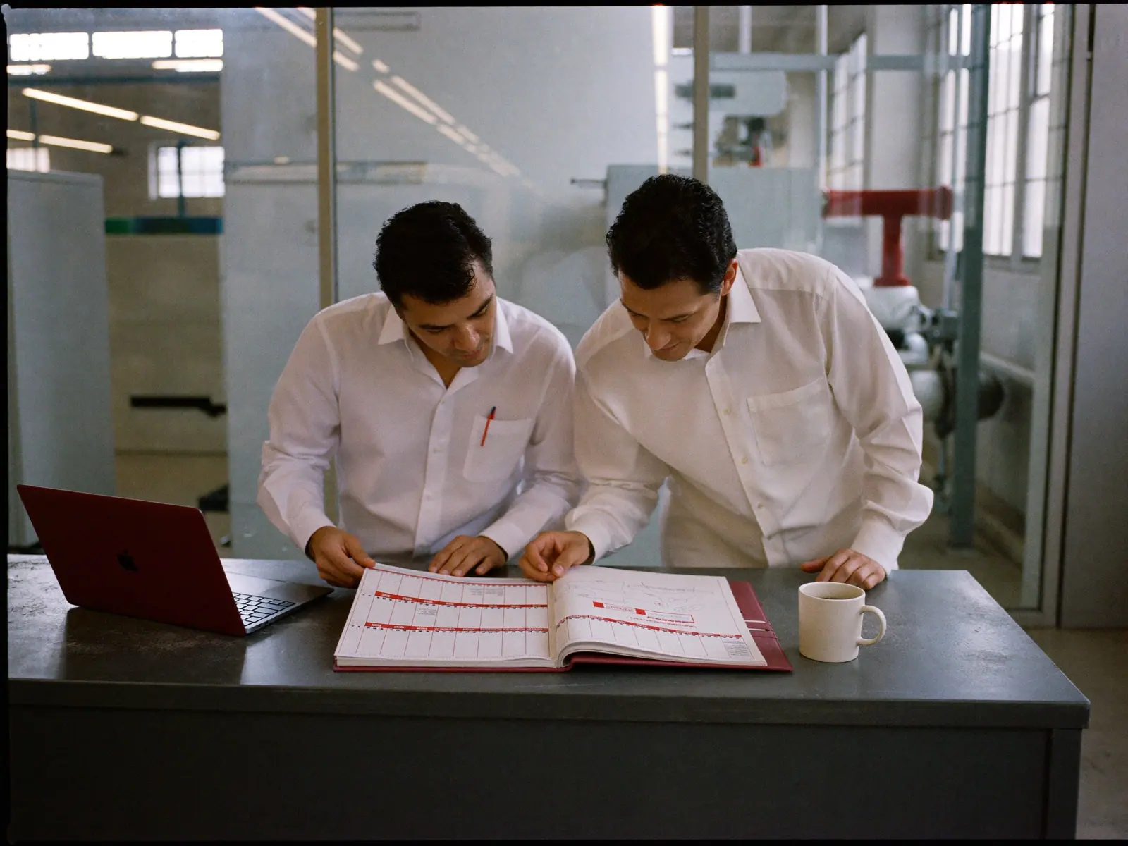 Dos planeadores revisando un calendario de mantenimiento impreso