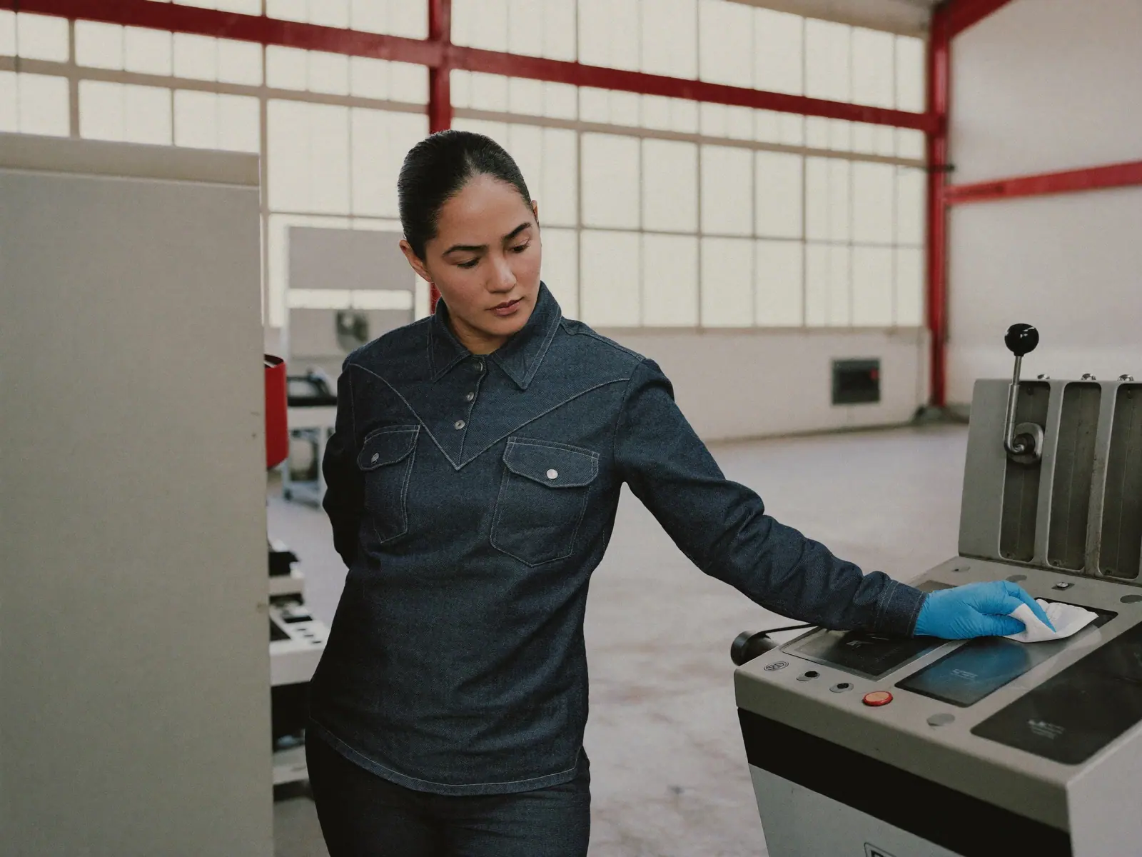 Técnico limpiando un tablero de una máquina industrial