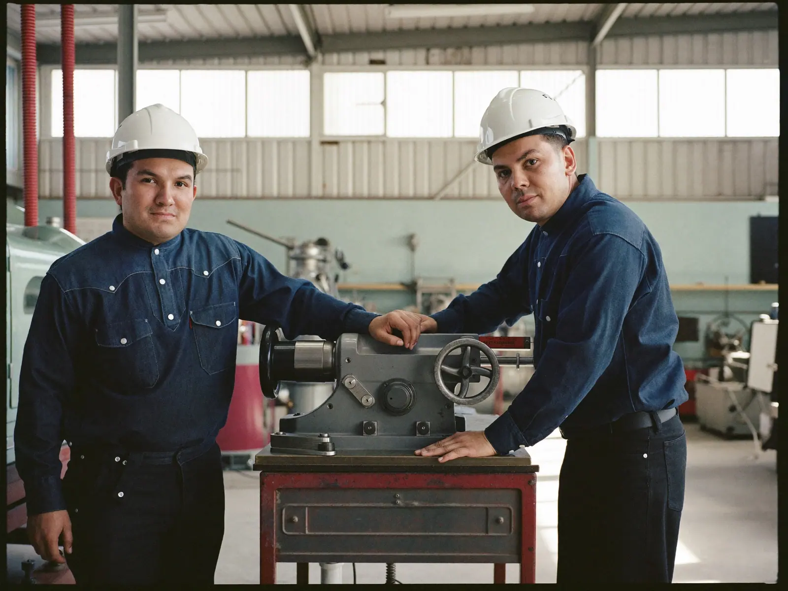 Técnicos nivelando una máquina recién reubicada en una nave industrial